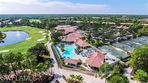 Drone / aerial view of a large body of water, a golf course, and a pool area