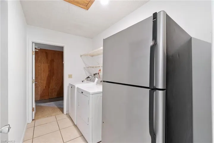 Laundry Room with light tile patterned floors, and independent washer and dryer and secondary refrigerator