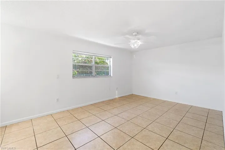Primary Bedroom with baseboards and ceiling fan and light color tile floor