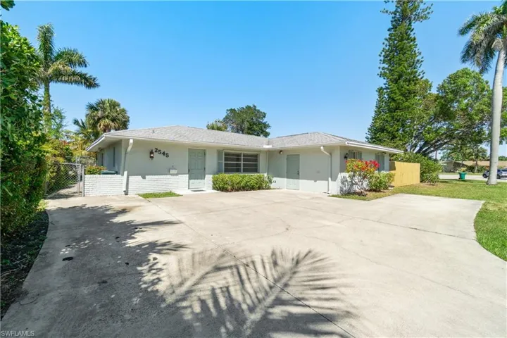 Ranch-style house featuring stucco siding, fence, driveway