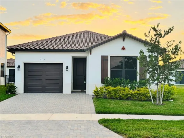 View of front of house featuring a garage and a lawn