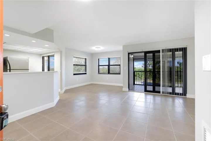 Empty room with light tile patterned floors and recessed lighting