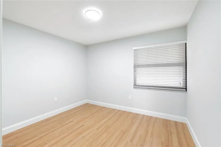 Spare room featuring light wood-style floors and baseboards