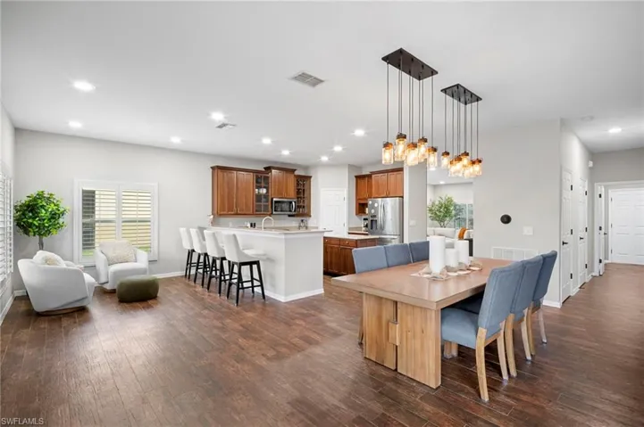 Dining room with recessed lighting, dark wood-style floors, and healthy amount of natural light