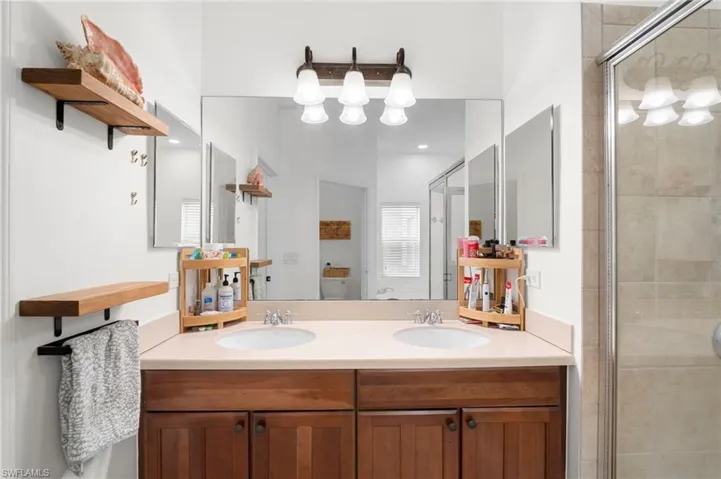 Full bath featuring double vanity and a stall shower