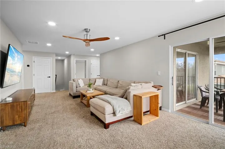 Living area featuring recessed lighting, ceiling fan, and light colored carpet