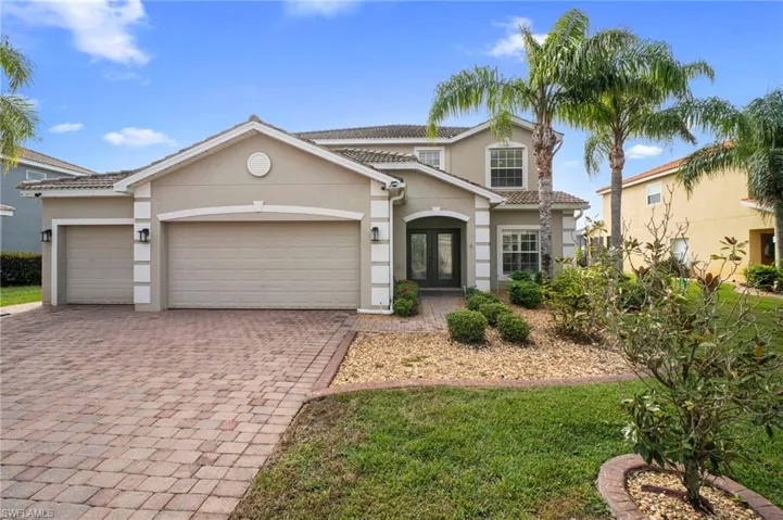 View of front of property featuring stucco siding, decorative driveway, a garage, and a tiled roof
