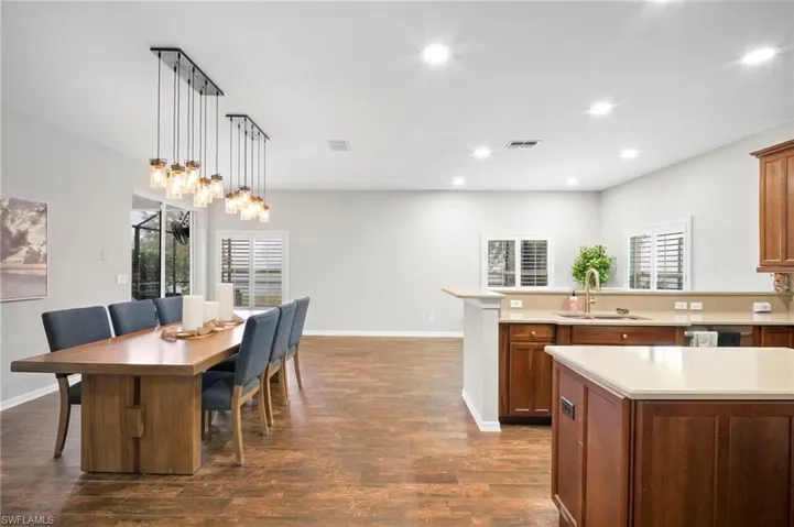 Kitchen with pendant lighting, dark wood-style flooring, a peninsula, recessed lighting, and brown cabinetry