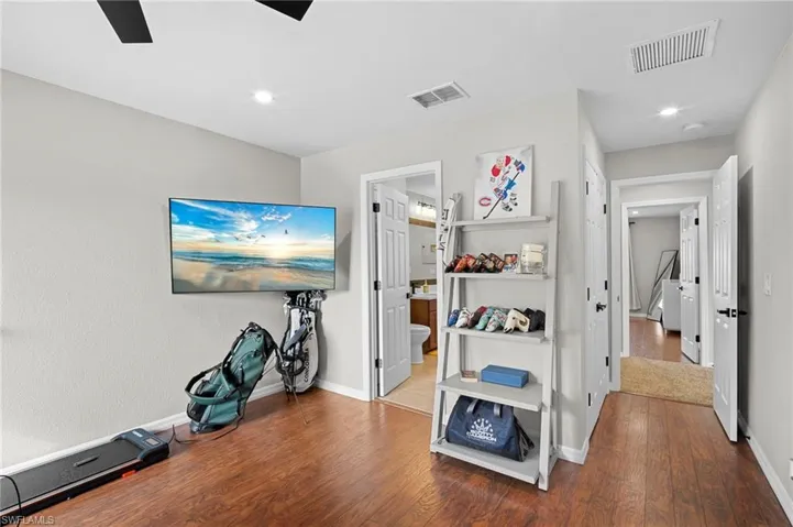 Hallway with wood-type flooring and recessed lighting