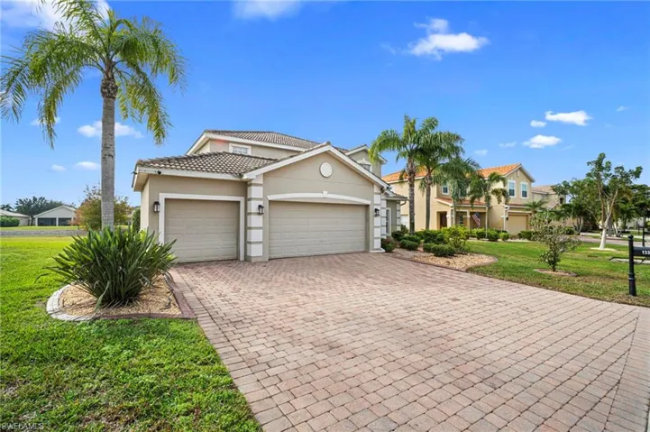 Mediterranean / spanish-style house featuring a front lawn, stucco siding, decorative driveway, and an attached garage