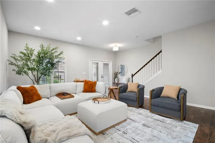 Living area featuring recessed lighting, wood finished floors, stairway, and french doors