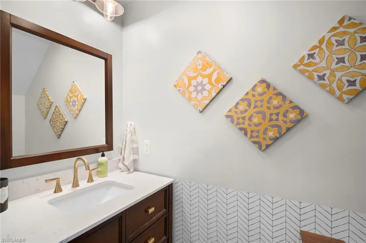 Bathroom with vanity, tile walls, and a wainscoted wall