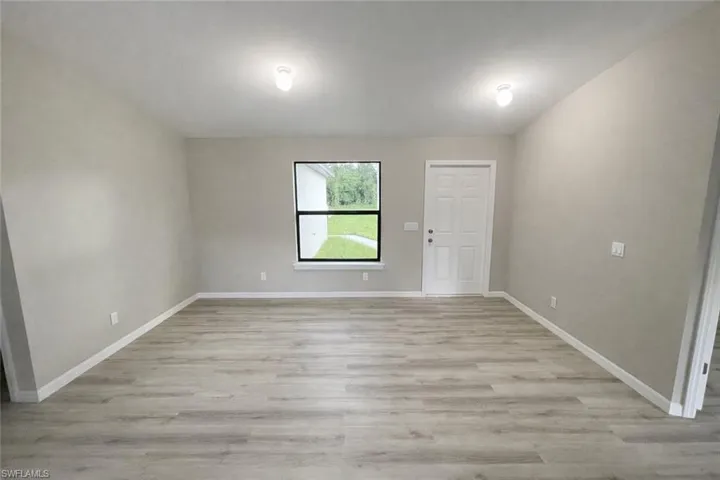 Spare room with light wood-style floors and baseboards