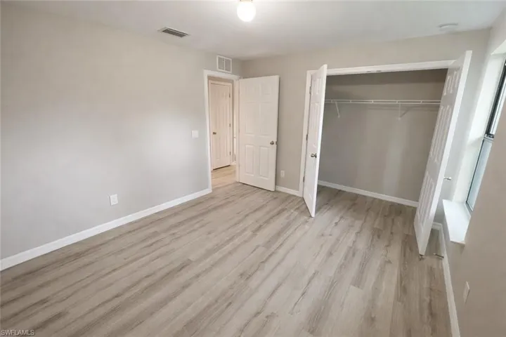 Unfurnished bedroom featuring light wood-style floors and a closet