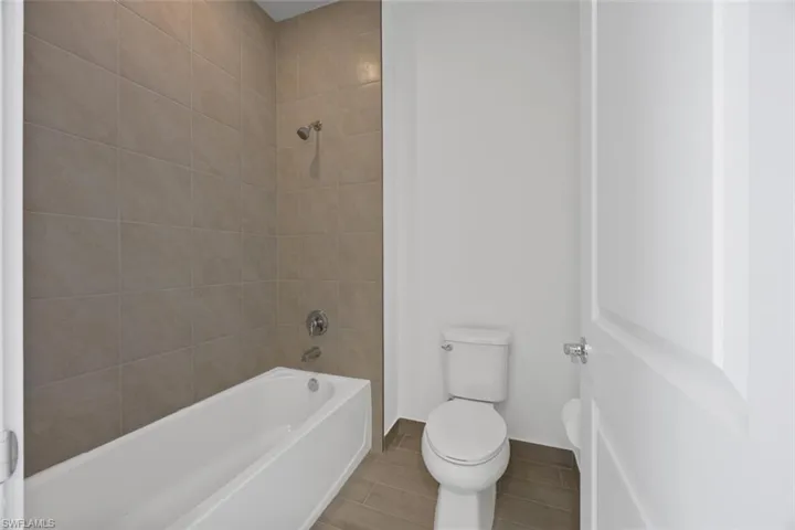Full bath featuring toilet and shower / bath combination