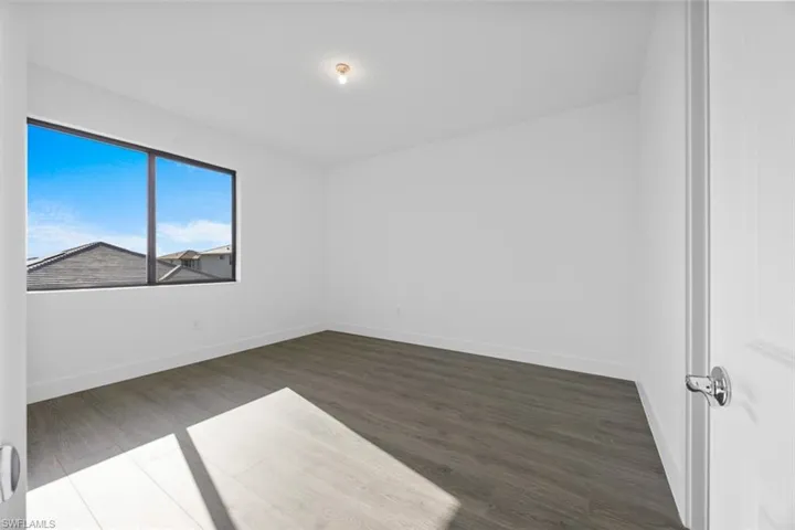 Empty room with baseboards and wood finished floors