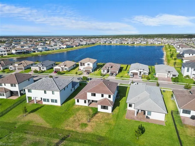 Birds eye view of property with a water view and a residential view