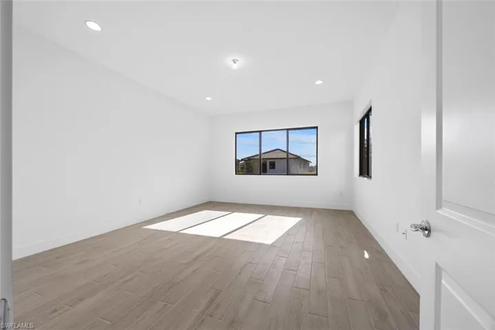 Empty room with light wood-style floors, recessed lighting, and baseboards