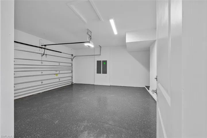 Garage featuring a garage door opener and electric panel
