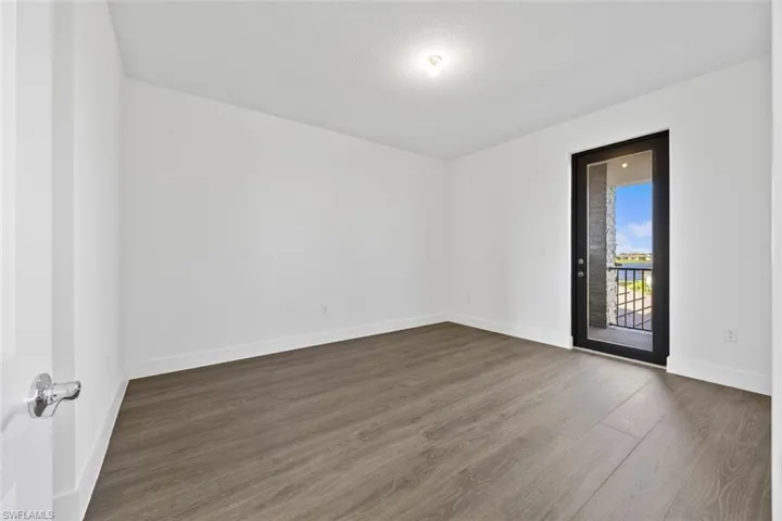 Unfurnished room featuring baseboards and dark wood-type flooring