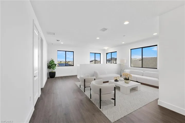 Living area featuring baseboards, visible vents, and dark wood-type flooring