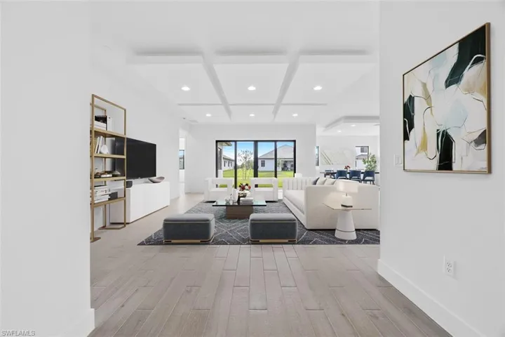 Living room with wood finished floors, beam ceiling, baseboards, recessed lighting, and coffered ceiling-Virtual Staging