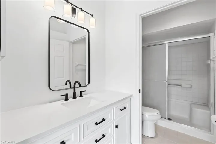 Bathroom with vanity, toilet, and an enclosed shower