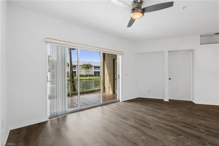 Unfurnished room featuring ceiling fan and dark wood-type flooring