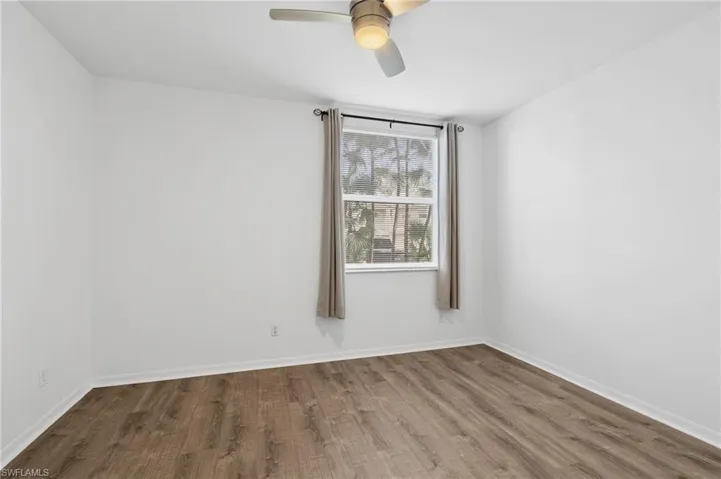 Unfurnished room with ceiling fan and wood-type flooring