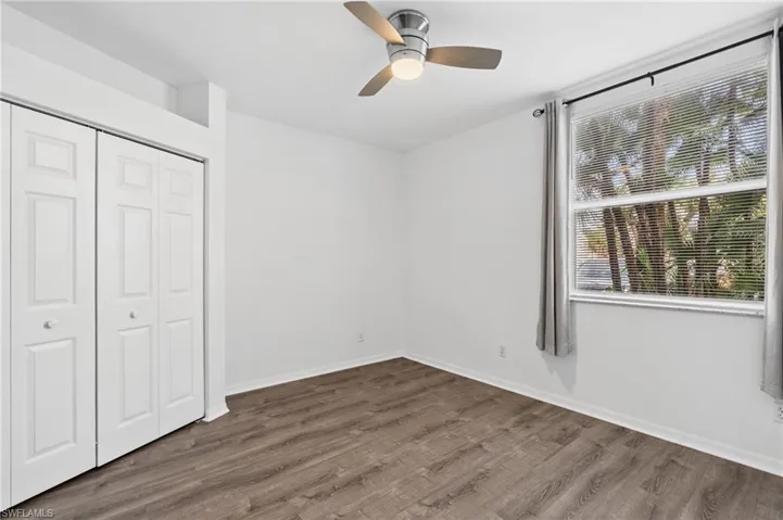 Unfurnished bedroom featuring dark hardwood / wood-style flooring, a closet, and ceiling fan