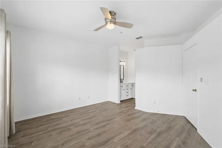 Spare room featuring ceiling fan and dark hardwood / wood-style floors