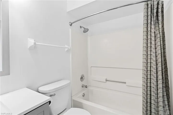 Full bathroom with vanity, shower / tub combo, and toilet