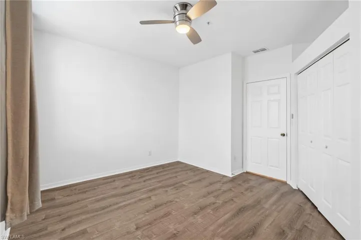 Unfurnished bedroom featuring ceiling fan, wood-type flooring, and a closet