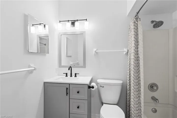 Full bathroom with shower / bath combo, vanity, and toilet