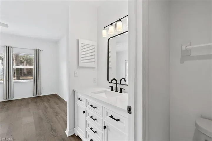 Bathroom featuring hardwood / wood-style flooring, vanity, and toilet