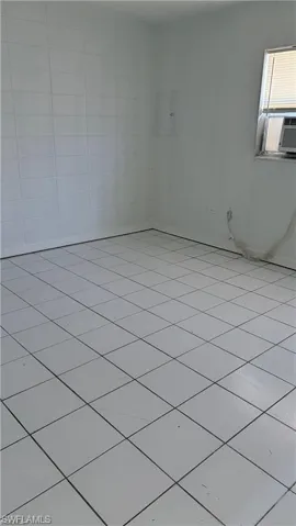 Unfurnished room with light tile patterned flooring and cooling unit