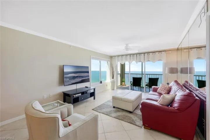 Tiled living room with a water view, ceiling fan, and crown molding