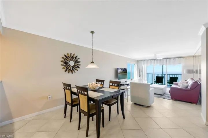 Dining space with ornamental molding and light tile floors