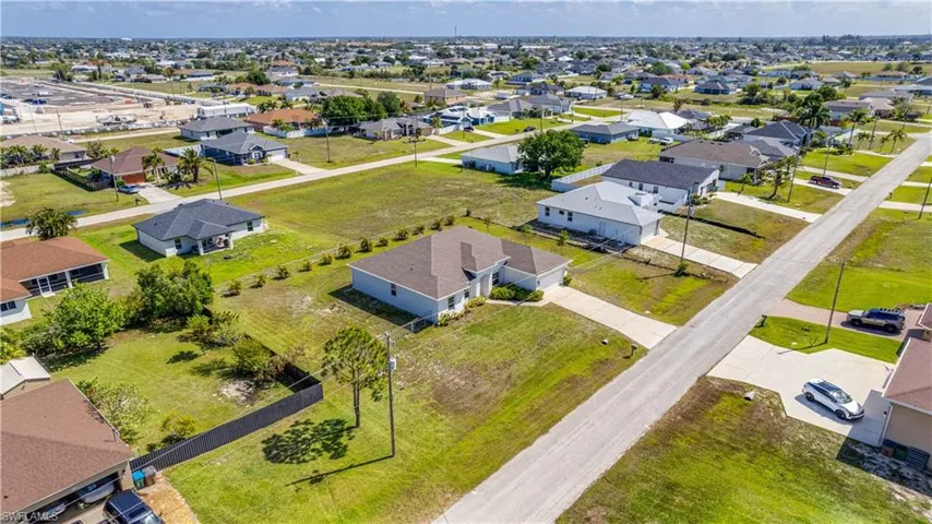 An aerial view of the property, showcasing the 4 lot site consisting of a 1/2 acre of land, all fenced.