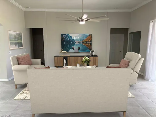 VIRTUALLY STAGED. Spacious living area featuring tiled flooring, crown molding, and a glass sliding door to the screened lanai