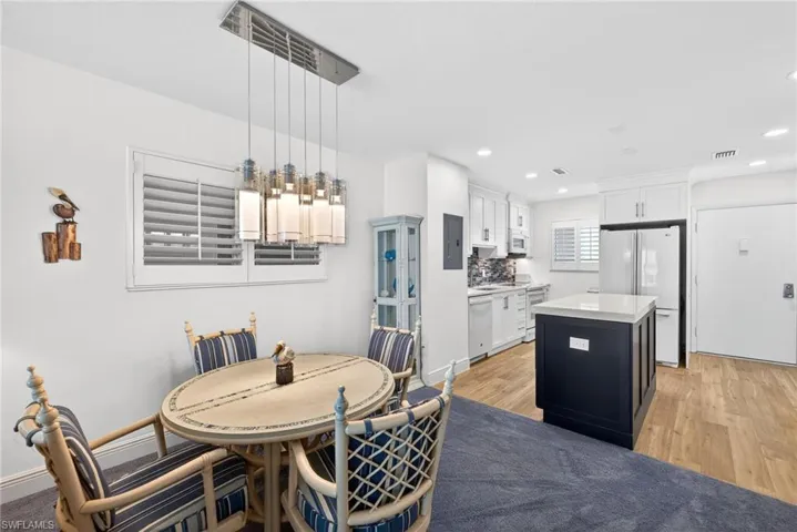 Dining space featuring light wood-style floors, recessed lighting, and electric panel