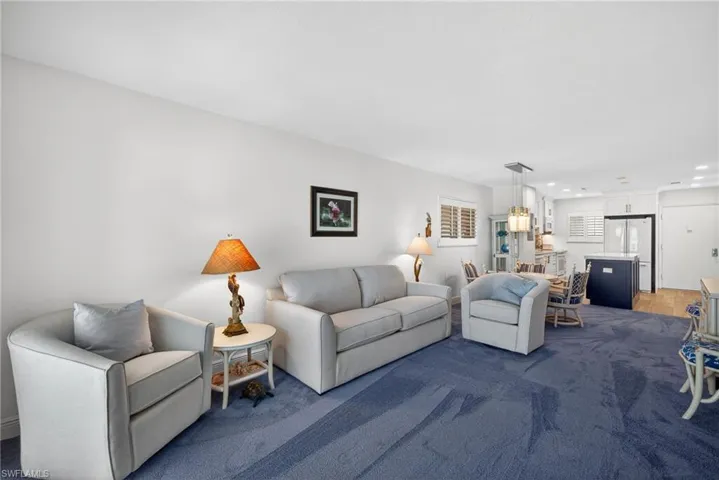 Living room featuring dark colored carpet and recessed lighting