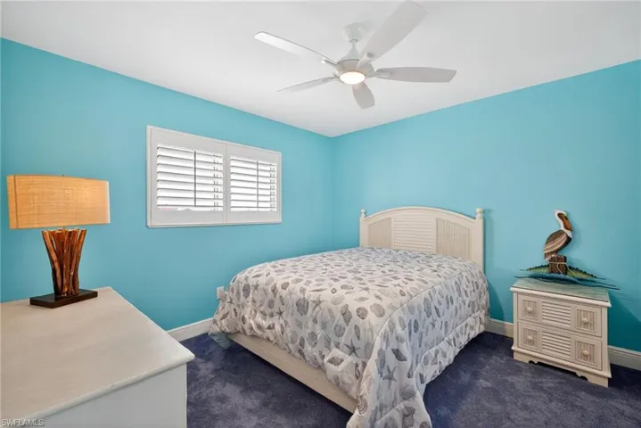 Bedroom with dark colored carpet and a ceiling fan