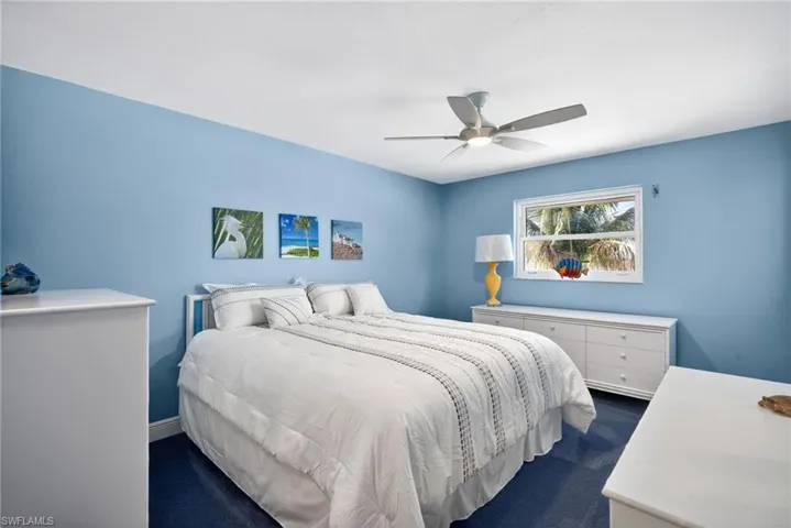 Bedroom featuring a ceiling fan and dark carpet