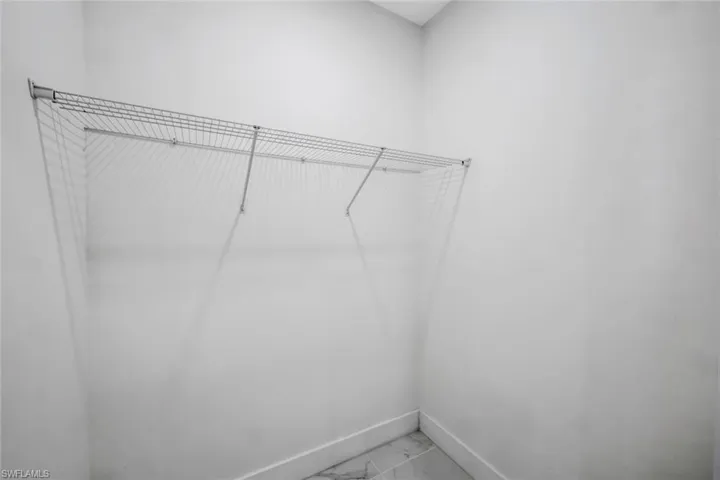 Walk in closet with light marble finish floors