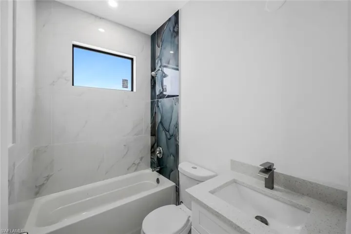 Full bath featuring vanity and shower / washtub combination