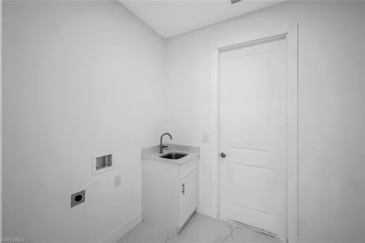 Laundry room with light marble finish flooring, washer hookup, cabinet space, and electric dryer hookup