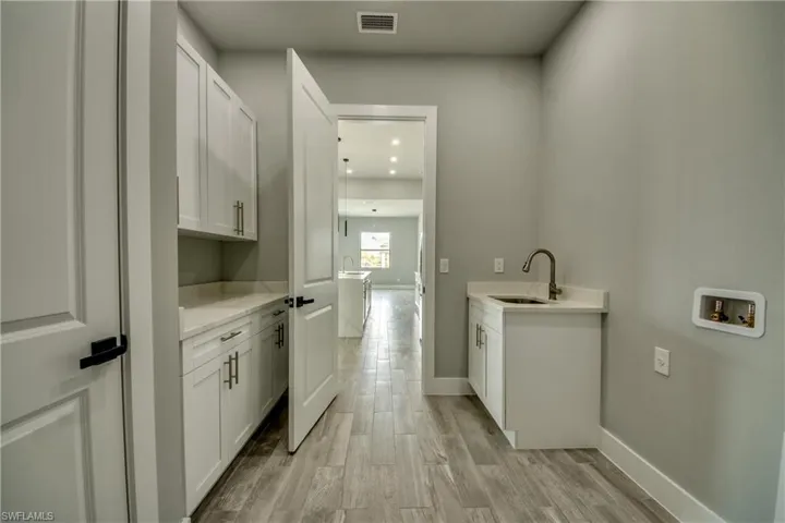 Stunning laundry room includes an upgraded sink and plenty of storage