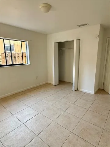 Unfurnished bedroom with a closet and light tile patterned flooring
