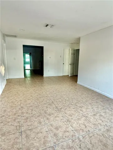Empty room with light tile patterned floors and baseboards